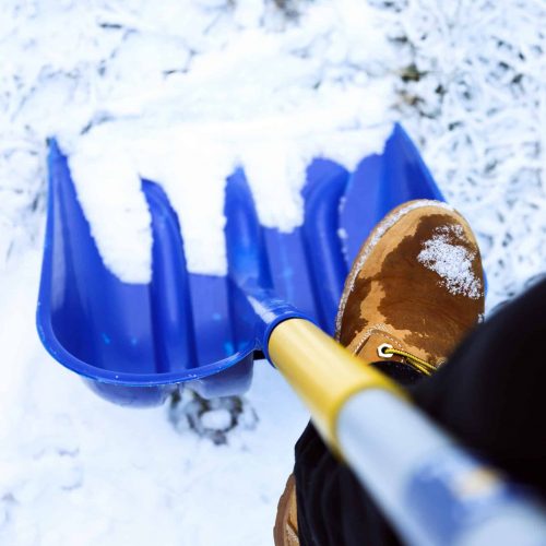 Man worker in uniform ,shoveling snow . close up image